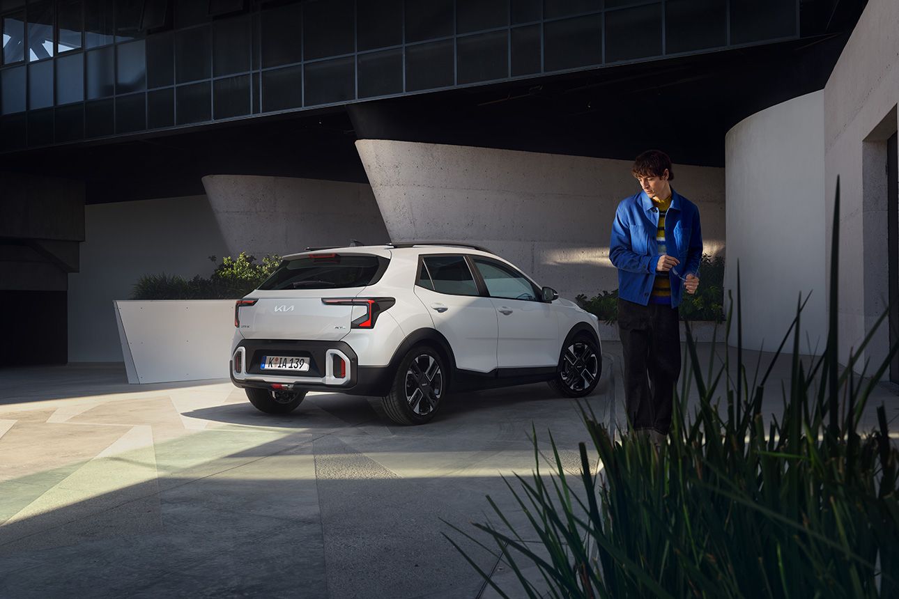 Frau lehnt seitlich an Kia EV4